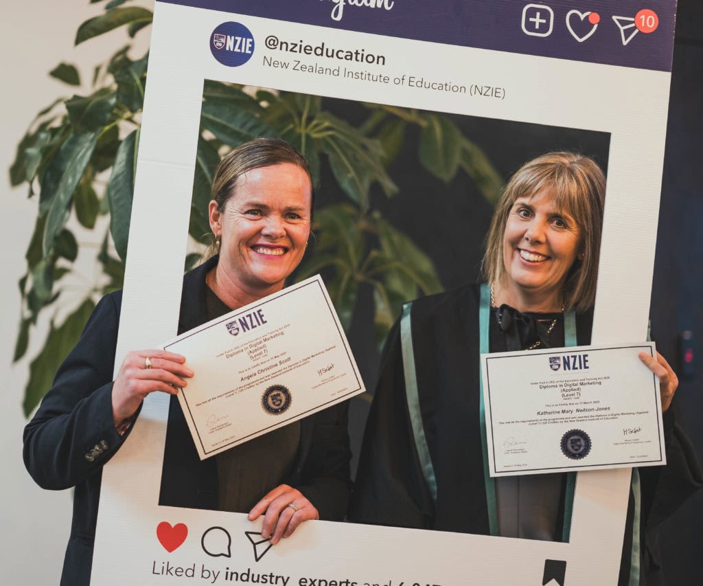 Two NZIE graduates posing at graduation ceremony